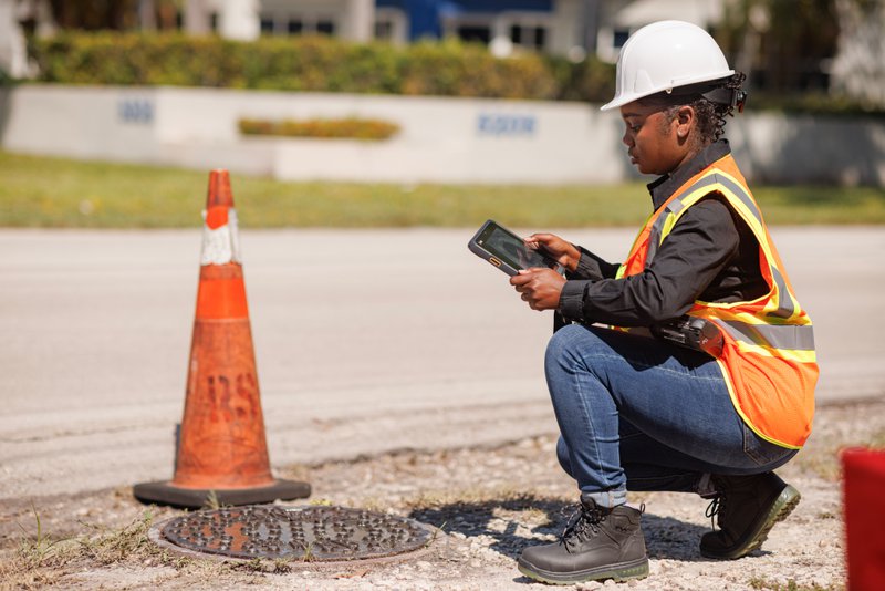 Utilities worker using a Zebra ET6X Tablet to record data in the field.
