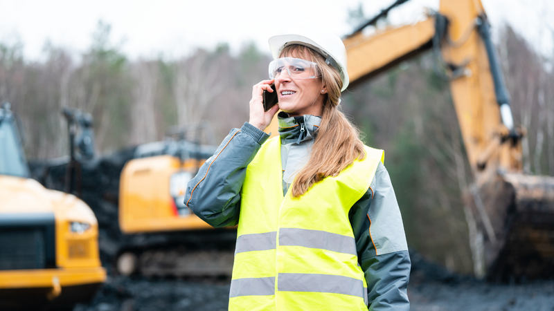 Construction worker at work using her own mobile device