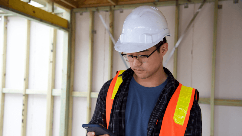 Construction worker using a consumer mobile device at work