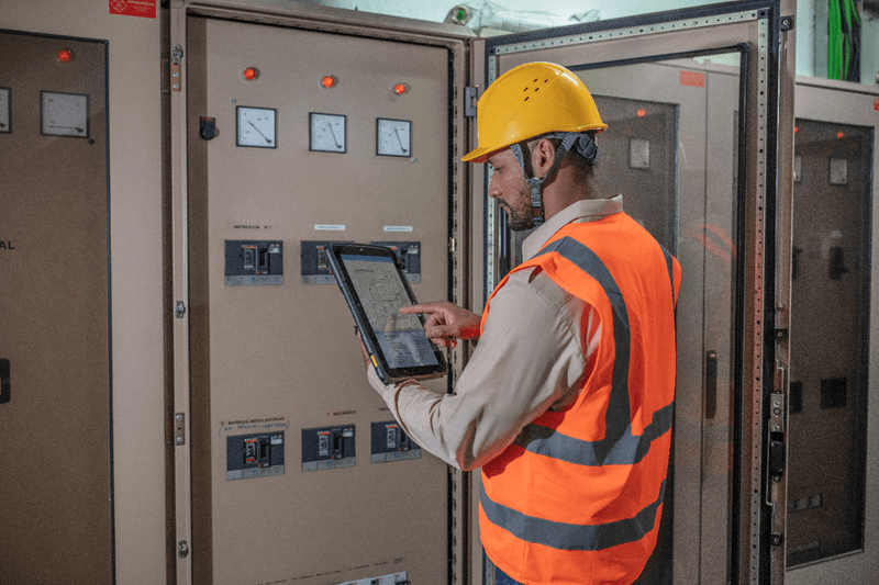 Facilities management worker using Zebra ET8X to check electrical equipment