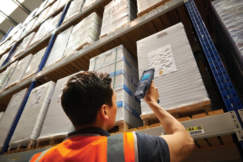 Warehouse worker using a Zebra Technologies MC9300 Ultra Rugged Mobile Touch Computer to scan the barcode on a far away pallet