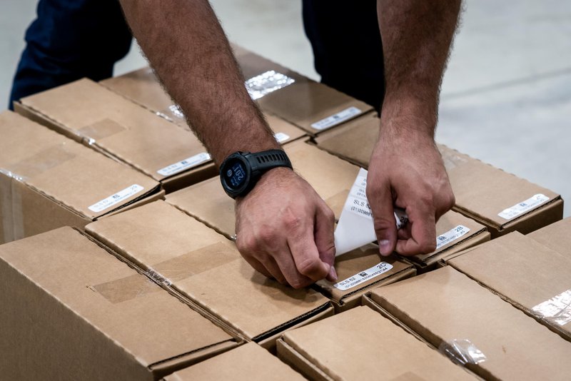 A warehouse worker sticking RFID labels to boxes