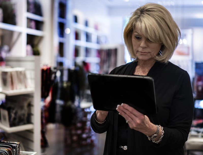 Retail worker in her store using the best tablets for retail business, the Zebra ET51