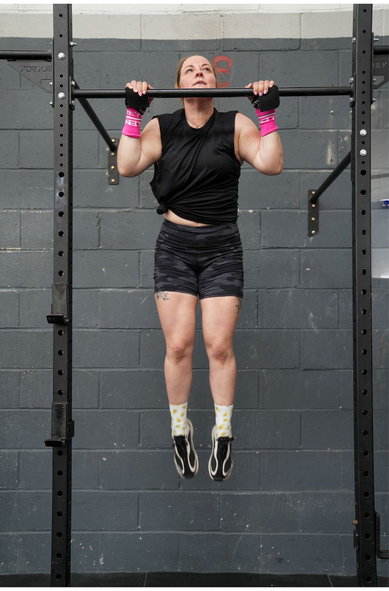 Project manager, Kat Hodgson doing a pull up on gym equipment