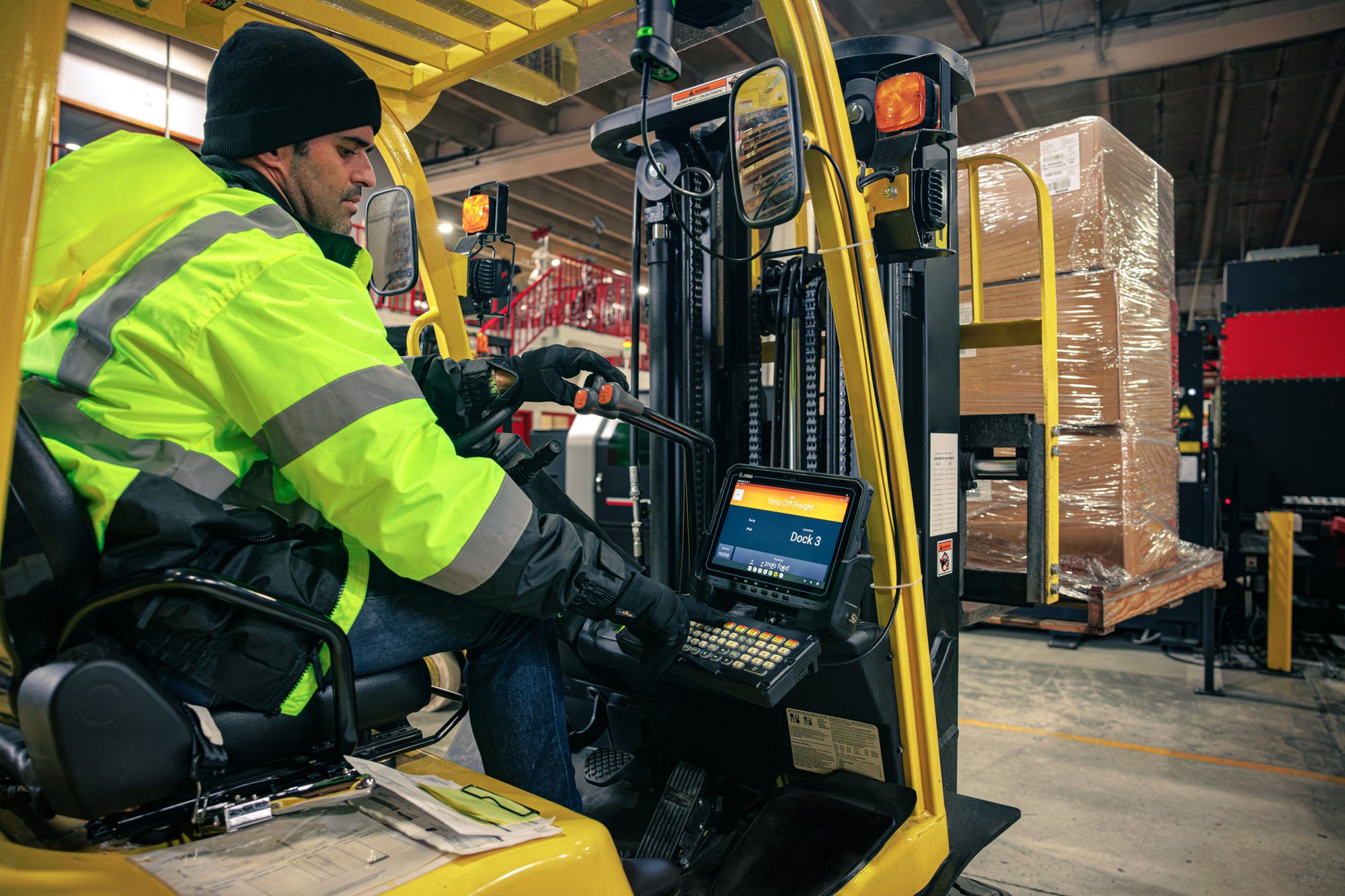 Warehouse worker driving forklift using a Zebra ET6x tablet