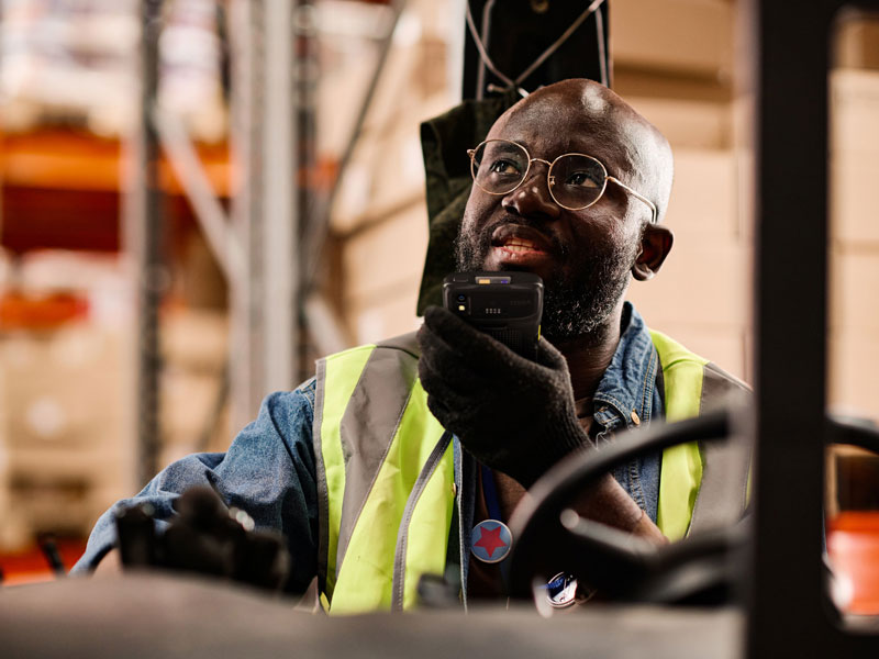 Warehouse worker driving forklift using a Zebra ET6x tablet