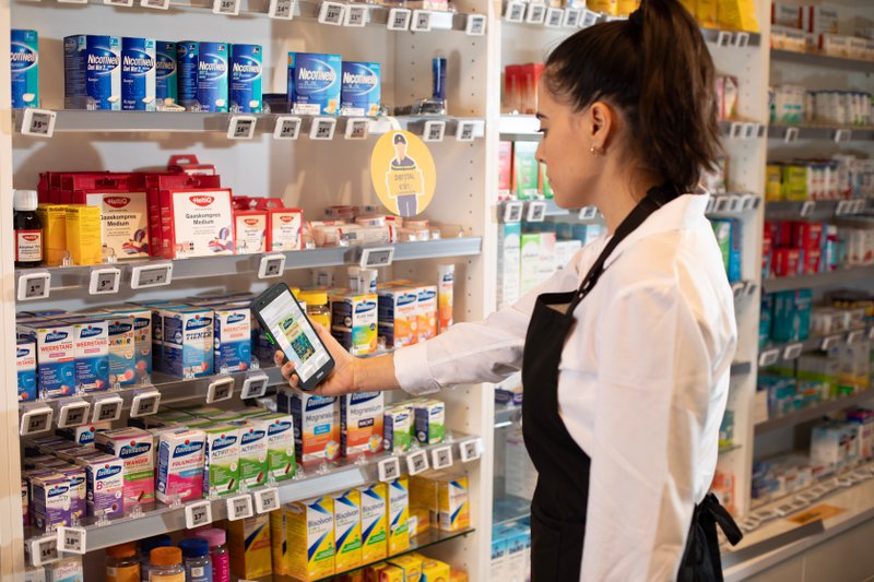 A store associate uses the Zebra TC501 to scan shelf products with AI-powered imaging and long-range barcode capture.